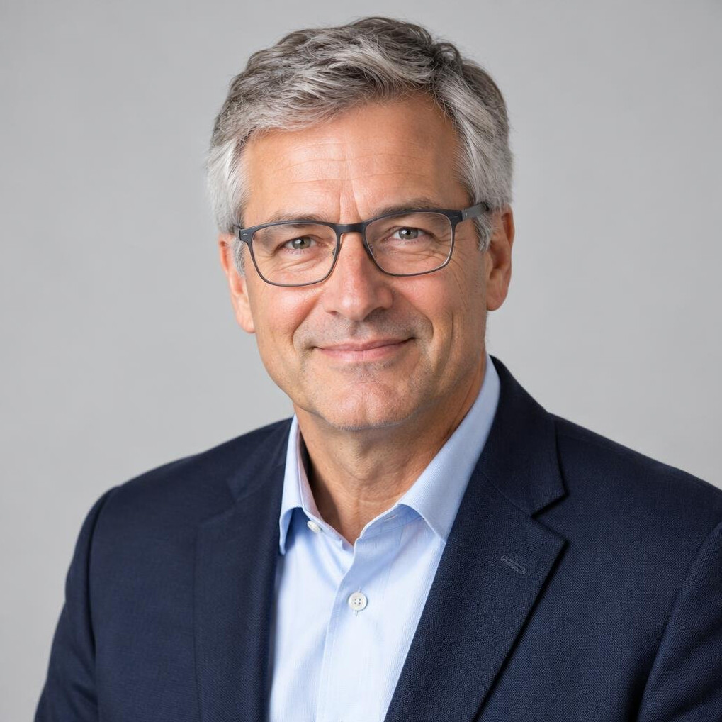 Portrait of a Swiss man in his 50s with grey hair wearing a blazer